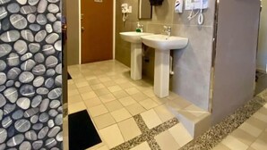 Een badkamer met twee wasbakken, een spiegel en een deur.