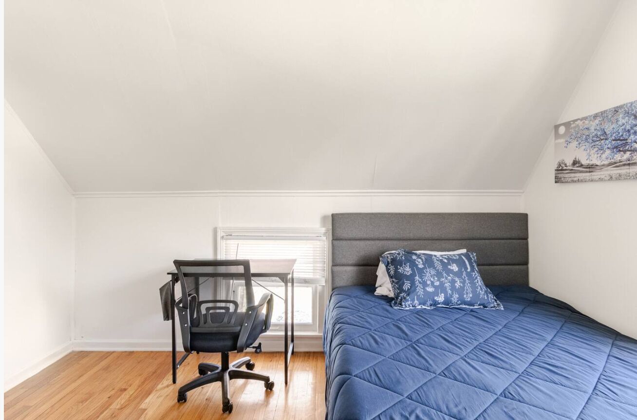 Une chambre à coucher avec un lit, un bureau et une chaise.