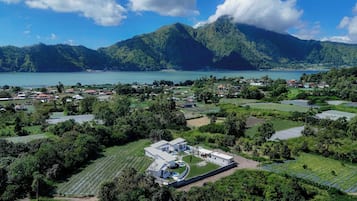 A coastal village with houses, fields, and a large building with a pool.