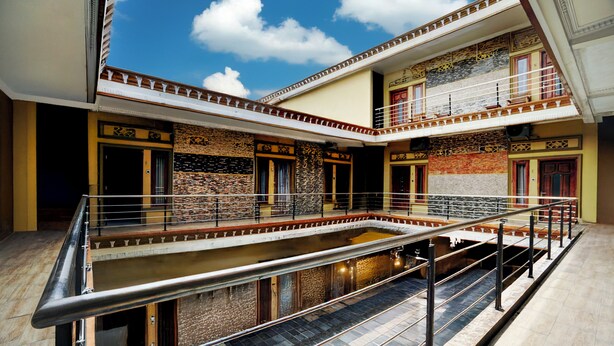 Un edificio de varios niveles con un patio central, balcones y una escalera.