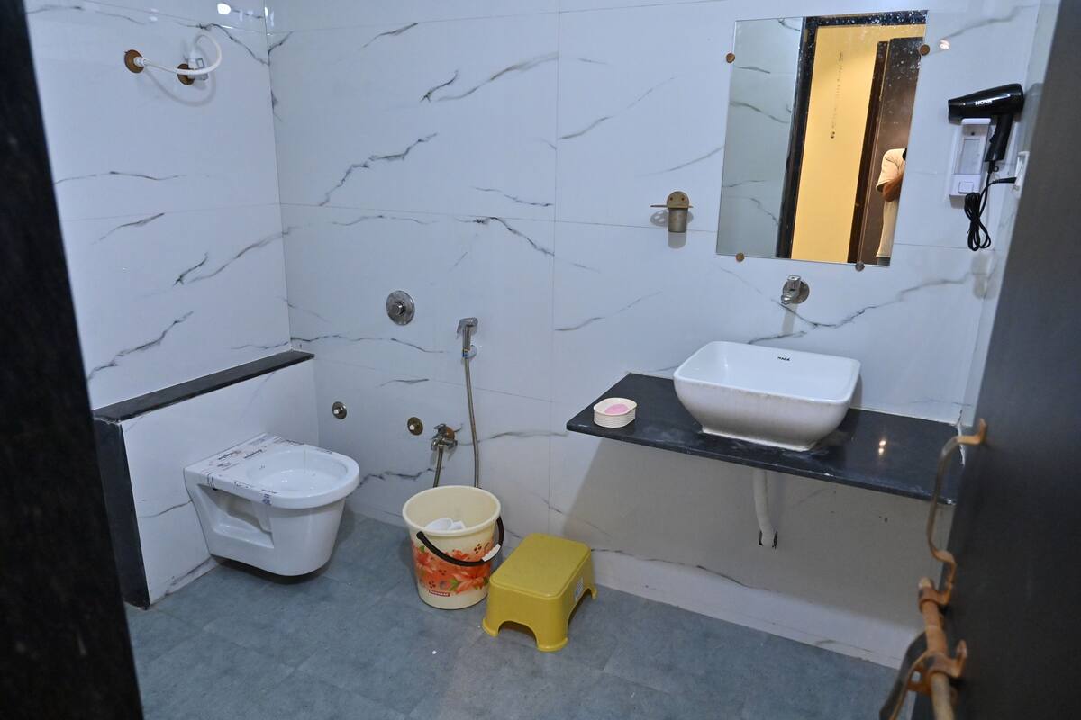 A bathroom with a toilet, sink, and mirror.
