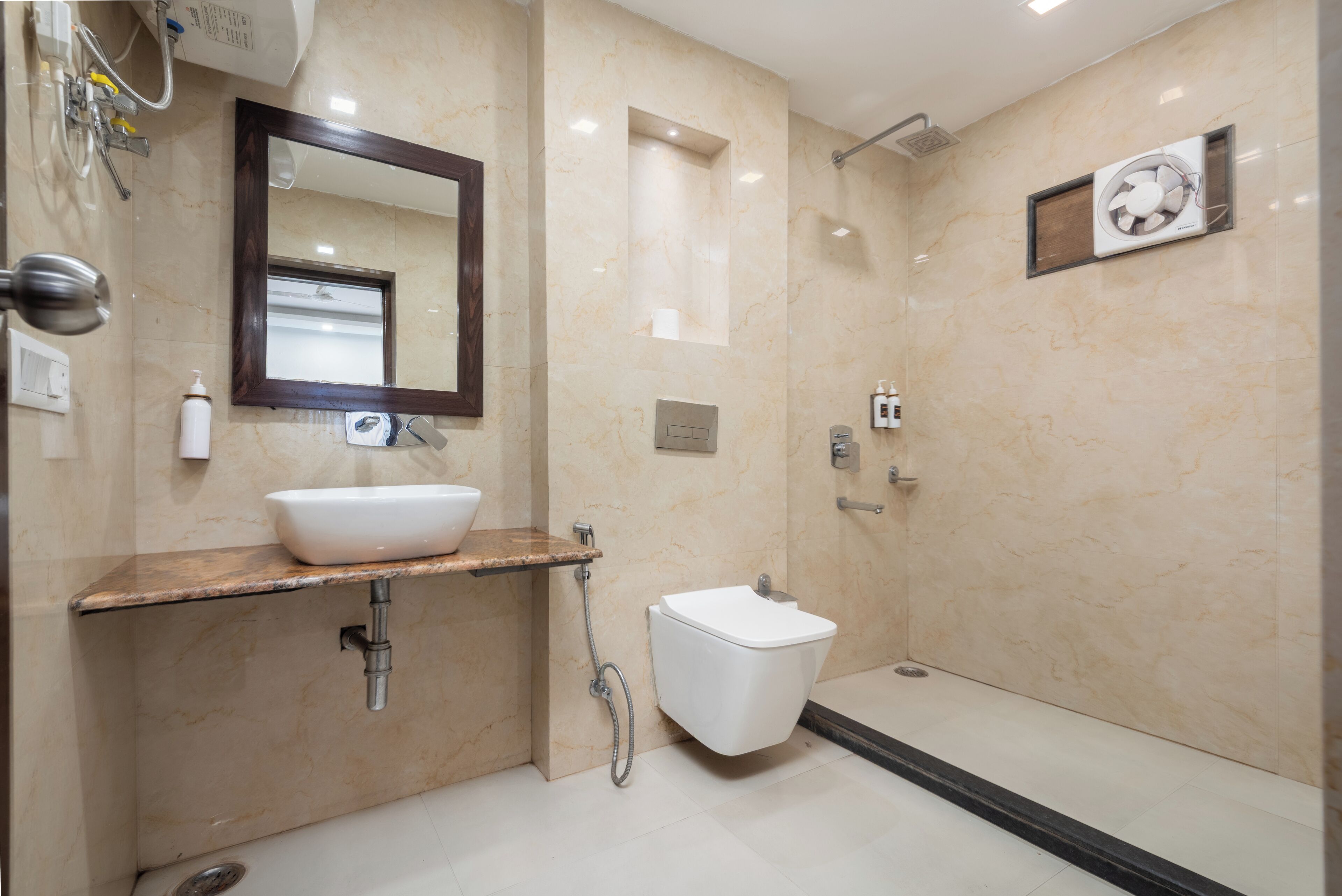 Une salle de bain moderne avec un lavabo en marbre, un miroir, des toilettes et une douche.