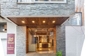 Entrada de una propiedad boutique con fachada de piedra, techo de madera y un mostrador de recepción con iluminación decorativa.