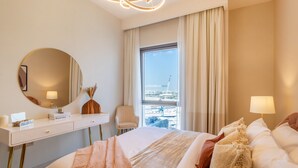 Une chambre d’hôtel avec un grand lit, un bureau avec un miroir, une chaise et une fenêtre donnant sur la ville.
