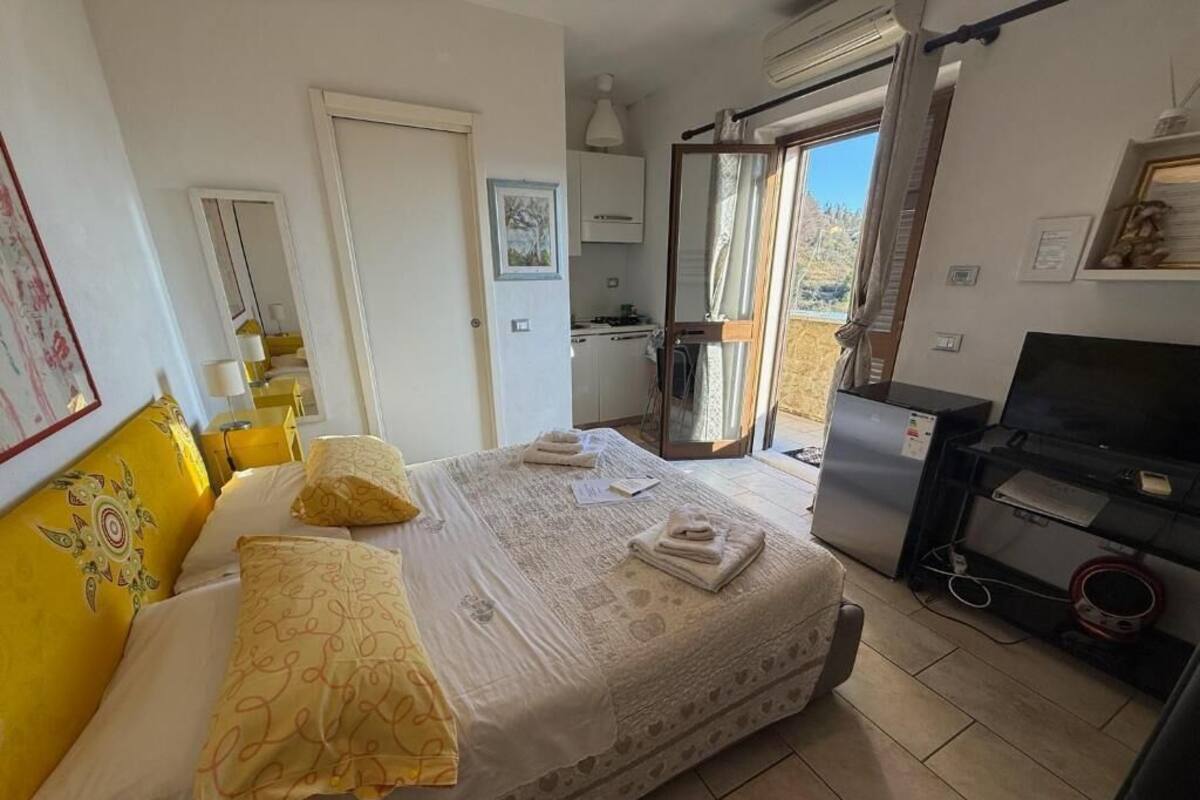 Une chambre à coucher comprenant un lit, un bureau, une chaise et un téléviseur.