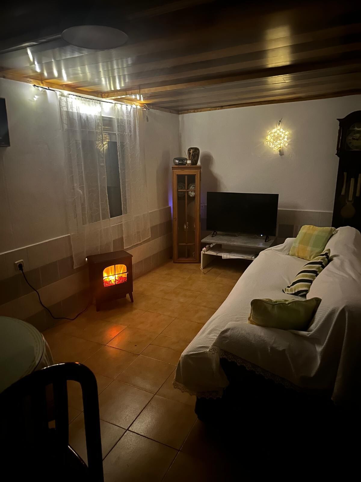 Une pièce confortable avec une cheminée, un lit, une télévision et un meuble en bois.