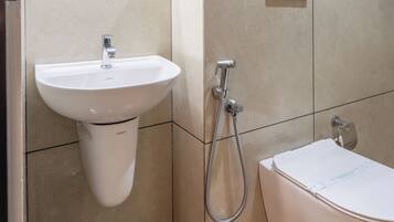 Ein modernes Badezimmer mit einem Standwaschbecken, einer Toilette und einer Dusche.