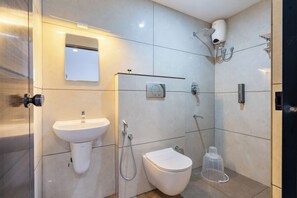 A modern bathroom with a sink, toilet, and shower. - MUGHAL SUITES (Kanayannur)