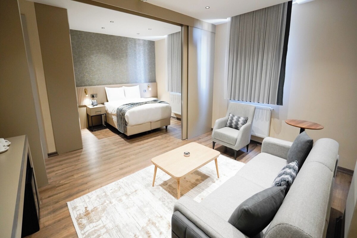 Une chambre d’hôtel moderne équipée d’un lit, d’un canapé, d’une petite table et d’une chaise.