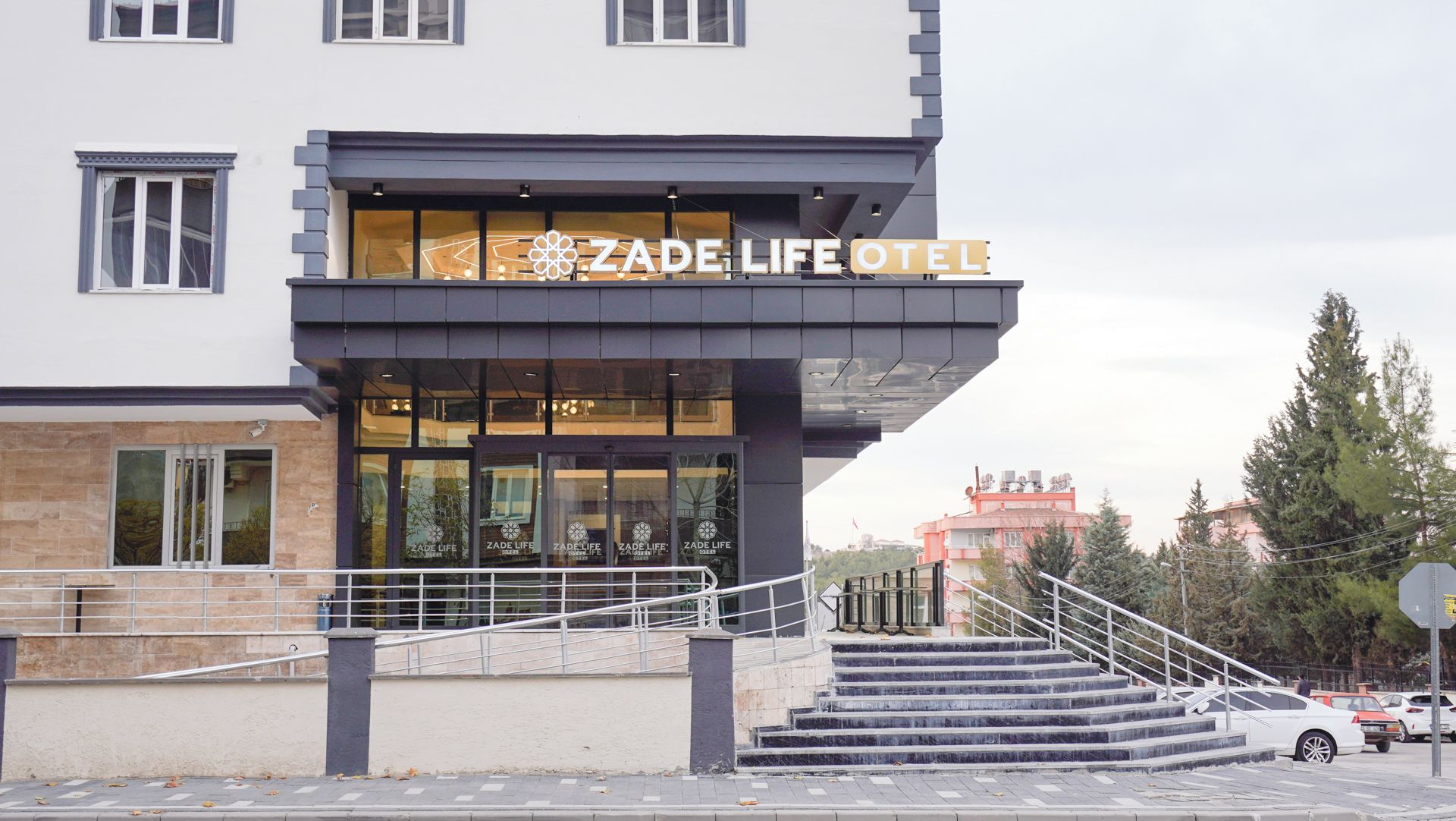 A hotel with a modern facade, a prominent entrance, and a staircase leading to the entrance.