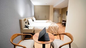 A hotel room with a bed, a desk with a laptop, a chair, and a small table. - Zade Life OTEL (Gaziantep)