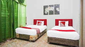 A hotel room with two beds, green curtains, and a wall with three flower paintings. - Hotel O Banda Aceh near Masjid Raya Baiturrahman formerly Wisma Tsacita (Banda Aceh)