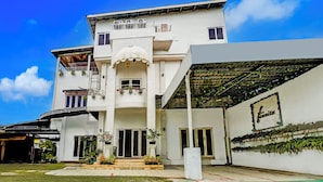 A multi-story building with a covered patio area, a balcony with potted plants, and a sign on the wall. - Hotel O Banda Aceh near Masjid Raya Baiturrahman formerly Wisma Tsacita (Banda Aceh)