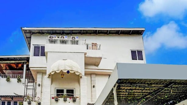 A multi-story building with a flat roof, a central entrance with a decorative arch, and balconies with railings. - Hotel O Banda Aceh near Masjid Raya Baiturrahman formerly Wisma Tsacita (Banda Aceh)