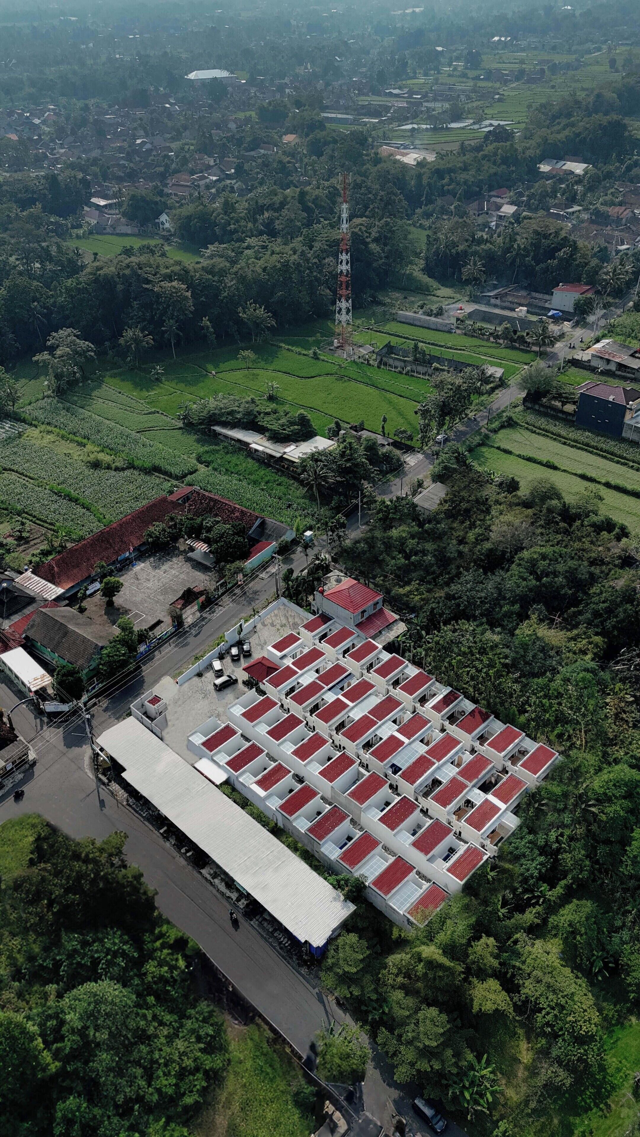 An aerial view of a residential area with a large building featuring a red-tiled roof and multiple windows.