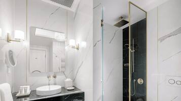 Un baño moderno con ducha acristalada, lavabo blanco y retrete.