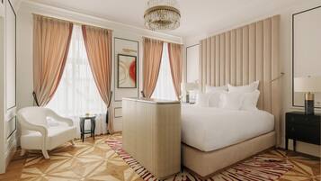 Een hotelkamer met een groot bed, een bureau, een stoel en een kroonluchter.