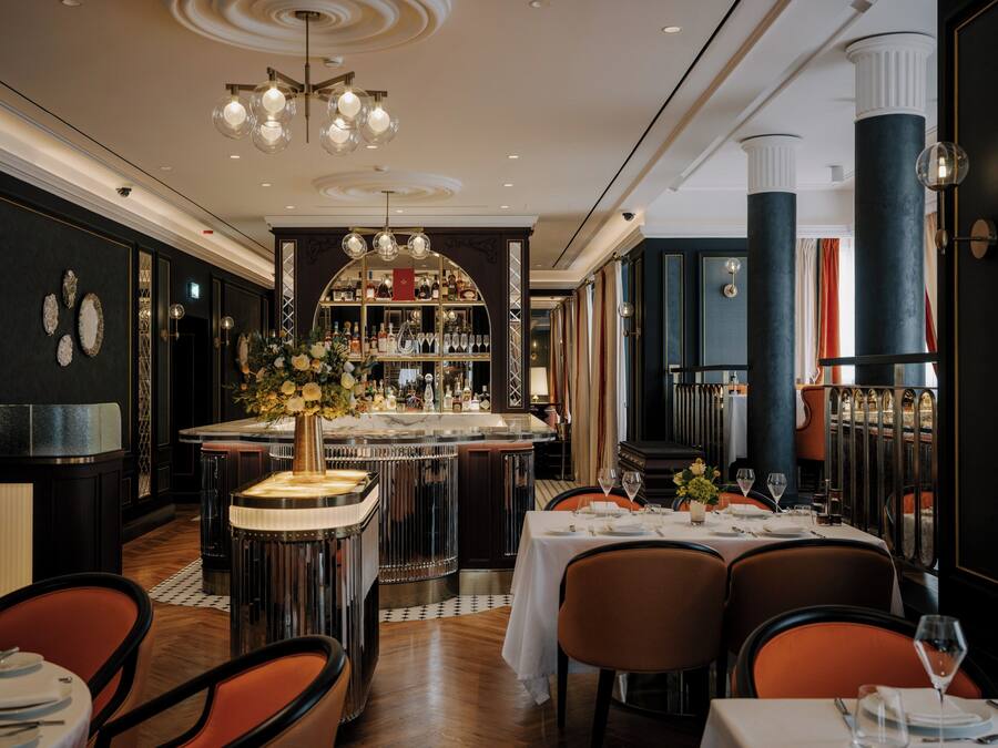 Um restaurante com área de bar, um candelabro e um pilar grande.