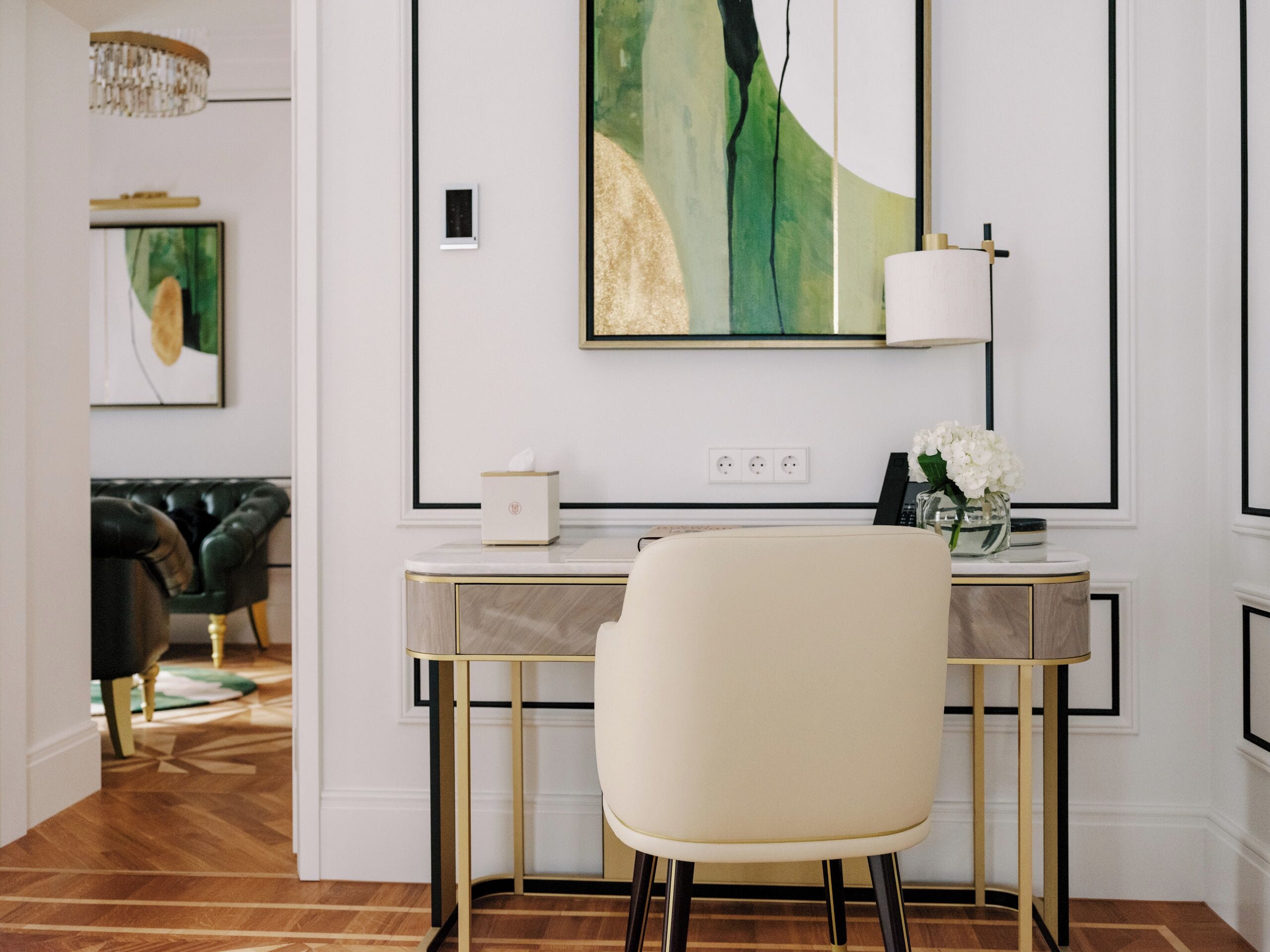 A modern room with a desk, chair, and artwork on the wall.