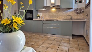 Una cocina moderna con gabinetes grises, un horno negro y un salpicadero de azulejos.