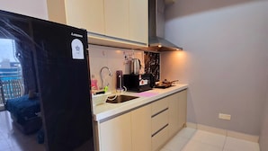 A modern kitchen with a black refrigerator, a sink, and a stove.