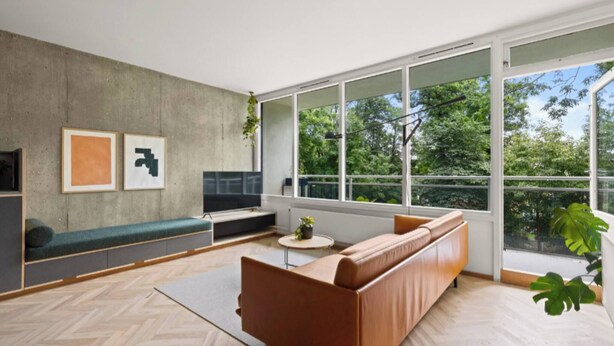 A modern living room with a large window, a sofa, a coffee table, and artwork on the wall. - NYC Studio in Central Oslo (Oslo)