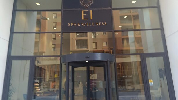 Een gevel van een gebouw met een bord waarop staat 'E1 SPA & WELLNESS'.