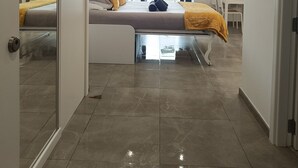 A modern hotel room with a bed, a desk, and a view of the city. - E1 18th Floor Studios, Sea & Beach Views (Gibraltar)