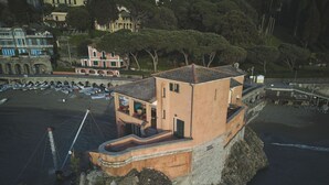 Un bâtiment situé sur la côte, doté d’un balcon donnant sur la mer et construit sur un promontoire rocheux.