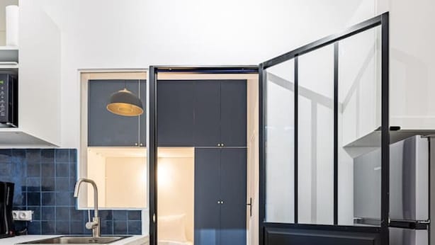A compact kitchen with a built-in oven, a sink, and a dining area. - 1#Cosystudio#Paris13#JardinDesPlantes (Paris)