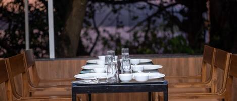 A dining table set for six with chairs, surrounded by a wooden bench.