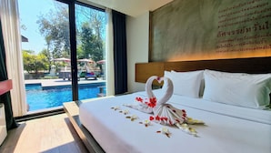 Ein Hotelzimmer mit einem großen Bett, Blick auf einen Swimmingpool und einer Wand mit Schrift.