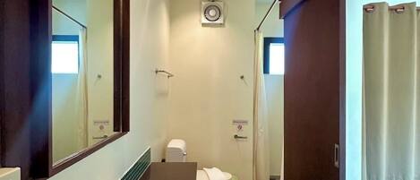 Une petite salle de bain avec un lavabo, un miroir et des toilettes.