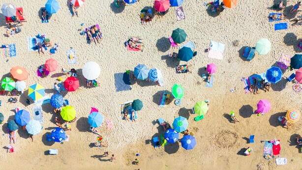 An aerial view of a beach with clear shallow waters, umbrellas, and people sunbathing. - FollowTheSun- Sea View House (Portoscuso)