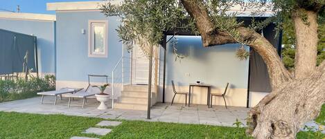 Un patio con una zona de estar, una escalera y un árbol.