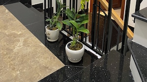 A staircase with potted plants on the handrail and a sign indicating an exit. - Floral Sea Homestay (Da Nang)