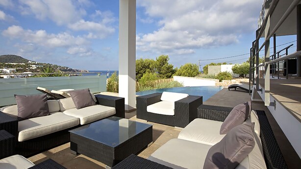 A covered outdoor seating area with a pool, overlooking a body of water and a hilly landscape. - My Rental Homes - Villa Bridget with private pool and terraces (San Jose)