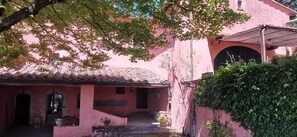 A pink building with a tiled roof, a covered entrance, and a small garden area. - Elegante villa con piscina a soli 12 km da Firenze ideale per famiglie e gruppi (Toscana)