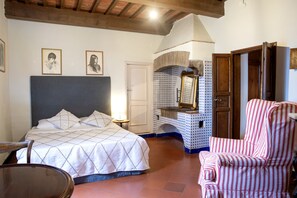 A bedroom with a bed, a chair, a mirror, and a door. - Elegante villa con piscina a soli 12 km da Firenze ideale per famiglie e gruppi (Toscana)