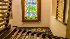 A staircase with a stained glass window at the top. - The Royal Alexandra Hotel by Compass Hospitality (Blackpool)