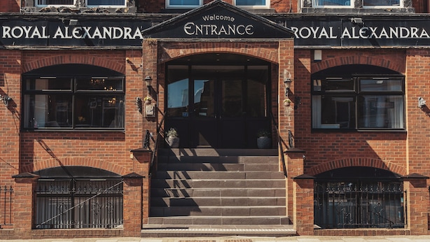 A brick building with the sign "Welcome Royal Alexandra ENTRANCE" above the entrance. - The Royal Alexandra Hotel by Compass Hospitality (Blackpool)