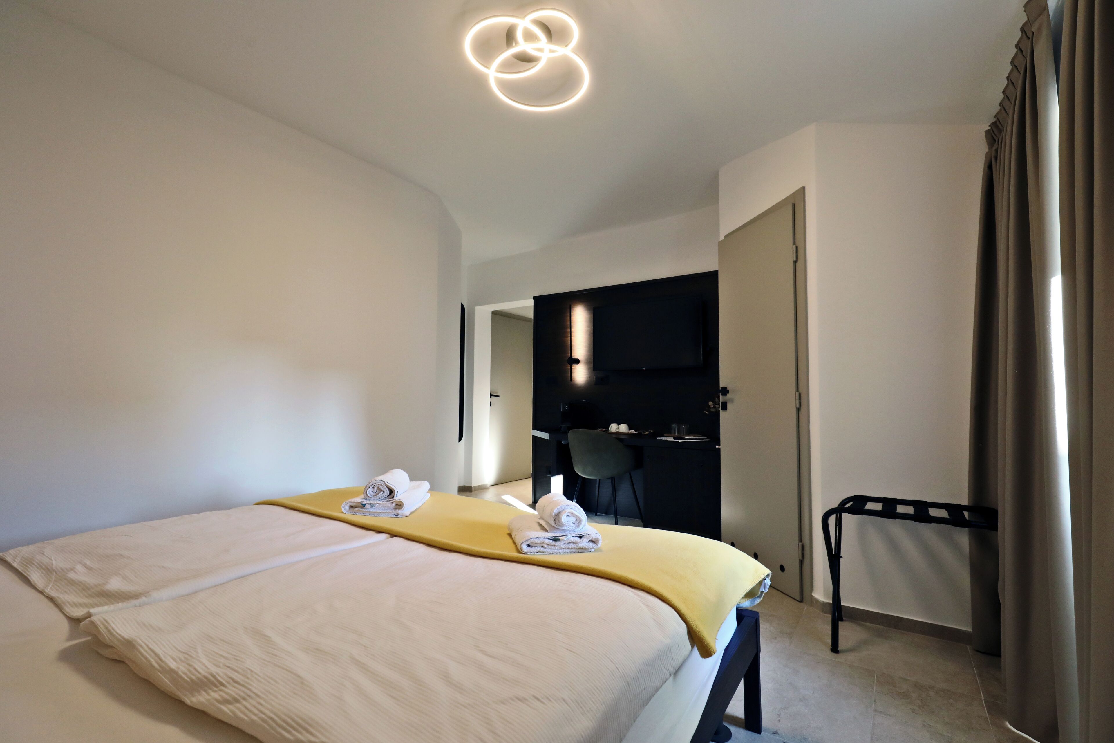 Une chambre d’hôtel avec un lit, un bureau et une chaise.