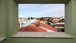 A view from a window of a building with red-tiled roofs and various buildings in the background. - B&B Arena Prestige Rooms (Pula)