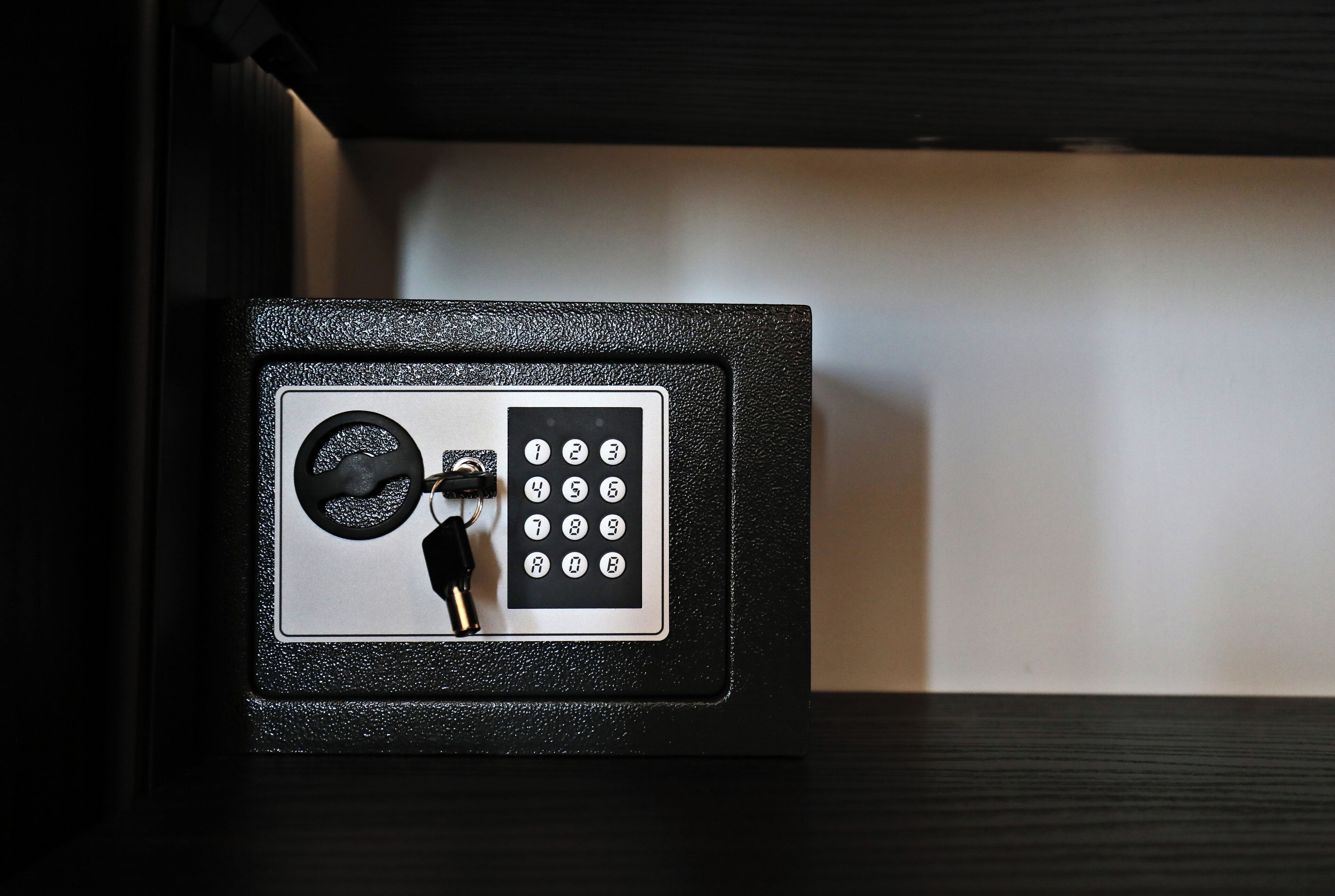 Una caja fuerte negra con dial de combinación y cerradura para llave.