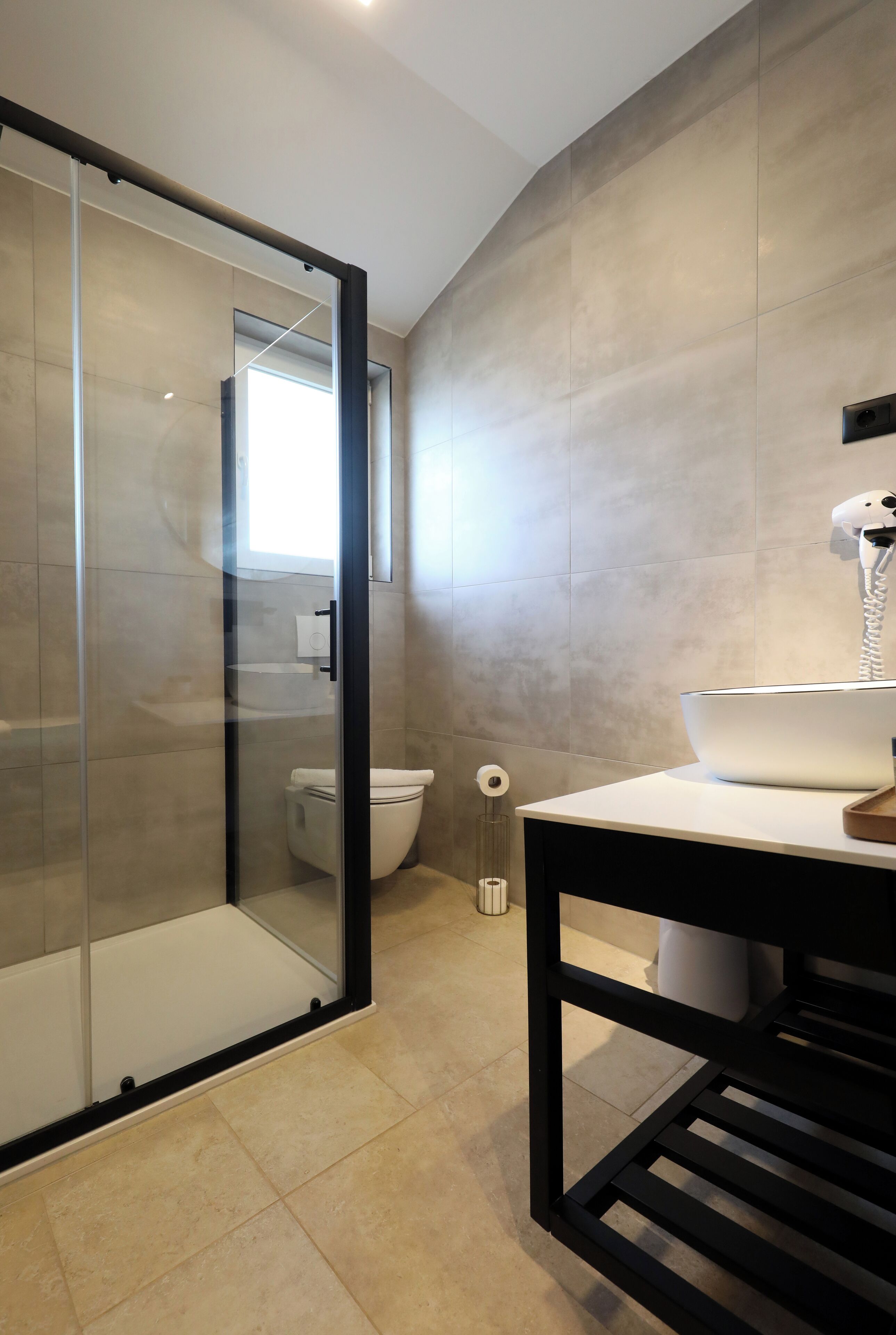 A modern bathroom with a glass shower enclosure, a toilet, and a sink with a mirror.
