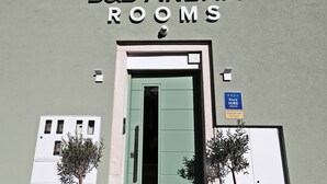 The entrance to B&B Arena Rooms with a green door, a sign indicating it is a Sobe-branded hotel, and two potted plants on either side. - B&B Arena Prestige Rooms (Pula)