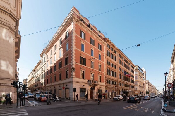 A multi-story building with a classic architectural style, featuring a prominent corner entrance and multiple windows. - CS Termini Nazionale Apartment n. 1 (Roma)