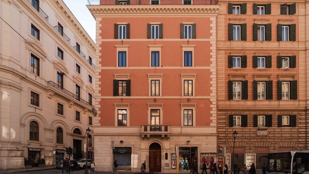 A multi-story building with a central entrance, large windows, and a ground-floor shop. - CS Termini Nazionale Apt n. 4 (Roma)