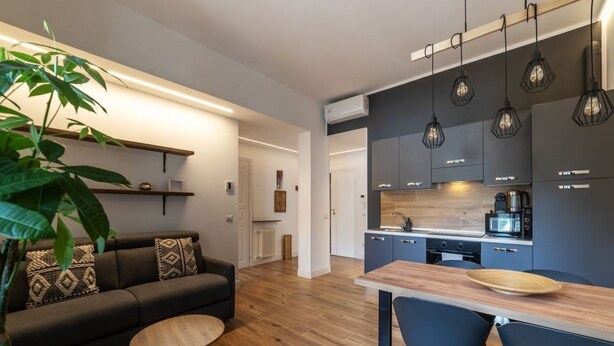 A modern kitchen with dark cabinets, a wooden countertop, and pendant lighting. - CS Vatican Metro Apartment (Roma)