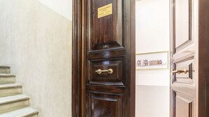 A wooden door with a brass handle and a sign above it.